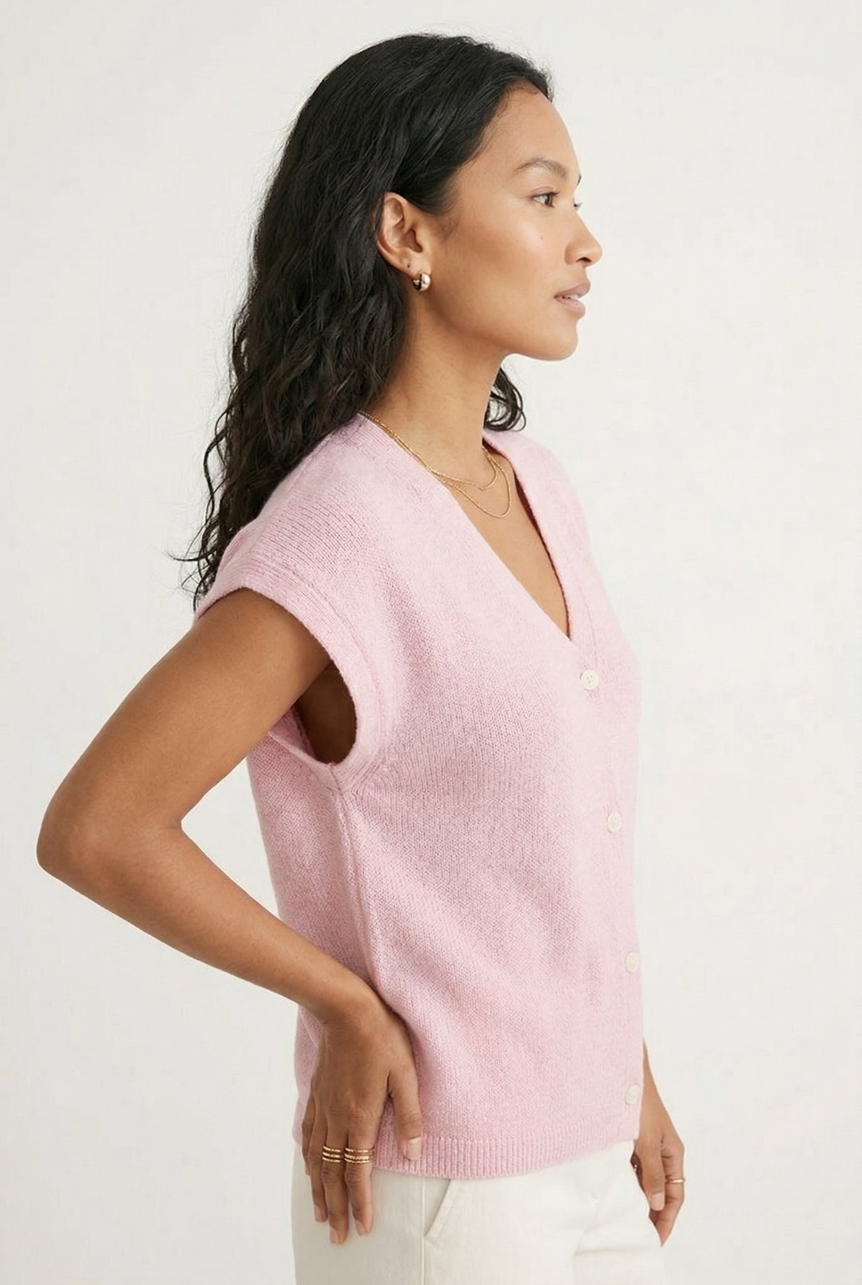 Woman modeling the LOHNR short sleeve v-neck knit top in light pink Ashen Rose featuring a button-down front.