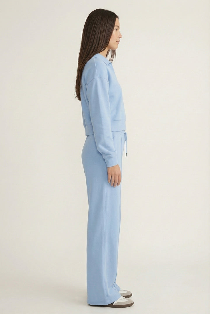 Model wearing the LOHNR Ventura Set in Sky, a premium soft scuba matching set featuring a sculpted V-neck and wide-leg pants for refined comfort.