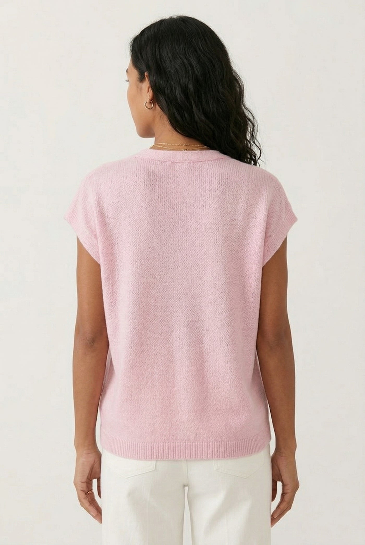 Woman modeling the LOHNR short sleeve v-neck knit top in light pink Ashen Rose featuring a button-down front.