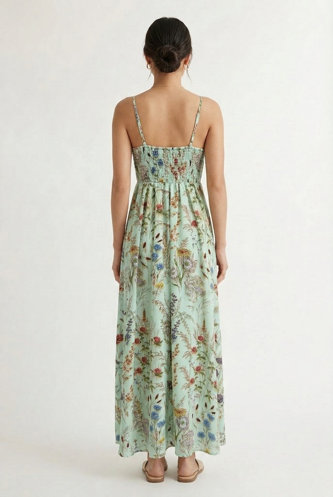 Woman wearing a matcha green floral print maxi dress with spaghetti straps