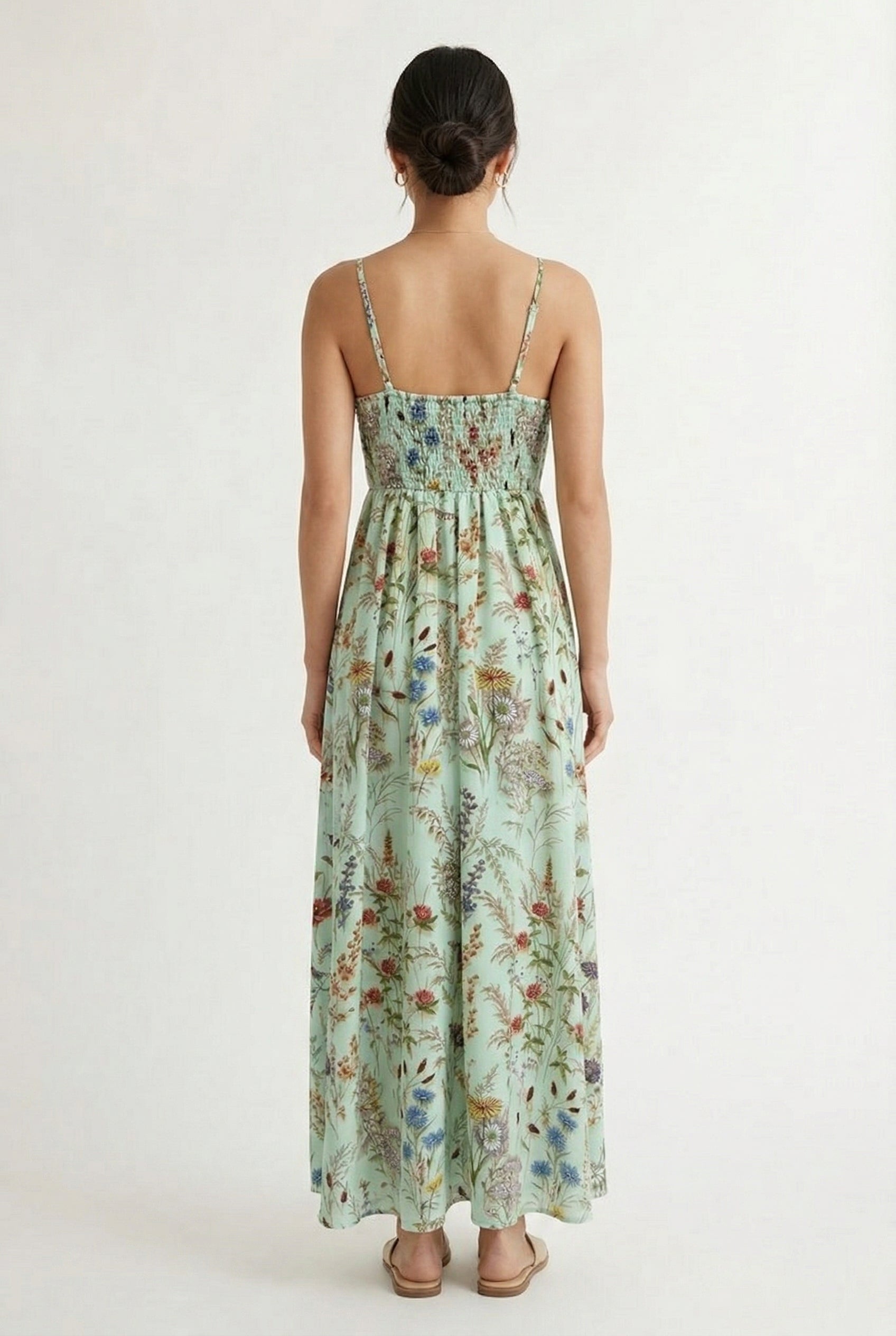 Woman wearing a matcha green floral print maxi dress with spaghetti straps
