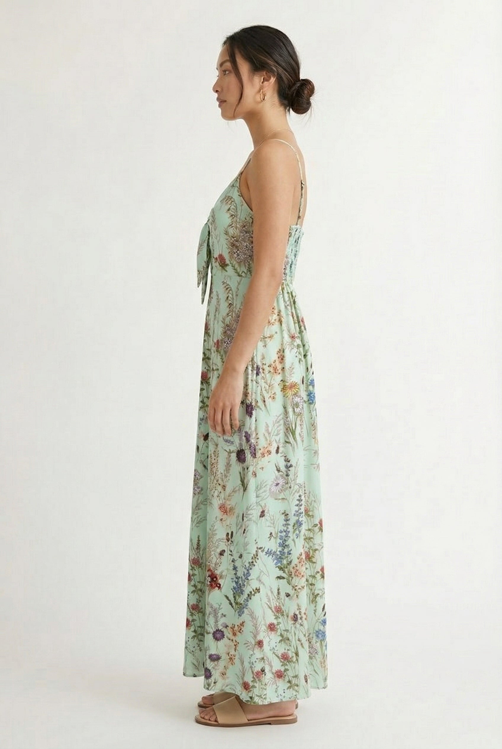 Woman wearing a matcha green floral print maxi dress with spaghetti straps