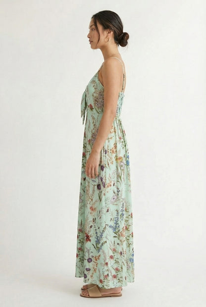 Woman wearing a matcha green floral print maxi dress with spaghetti straps