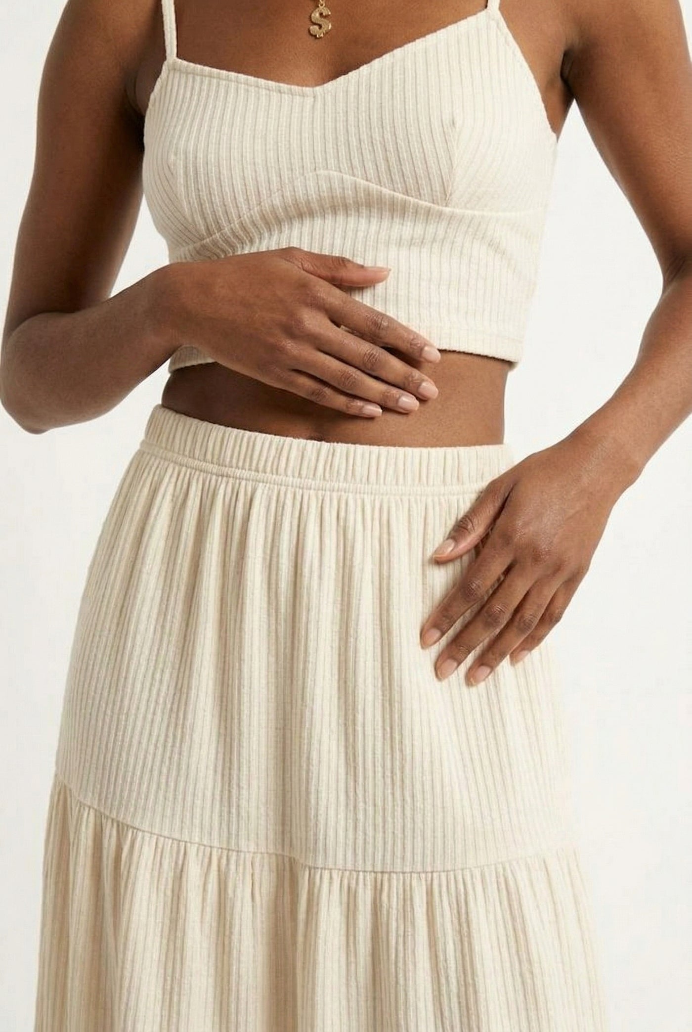 Woman modeling an Oat cream two-piece matching set featuring a spaghetti strap crop top and tiered maxi skirt