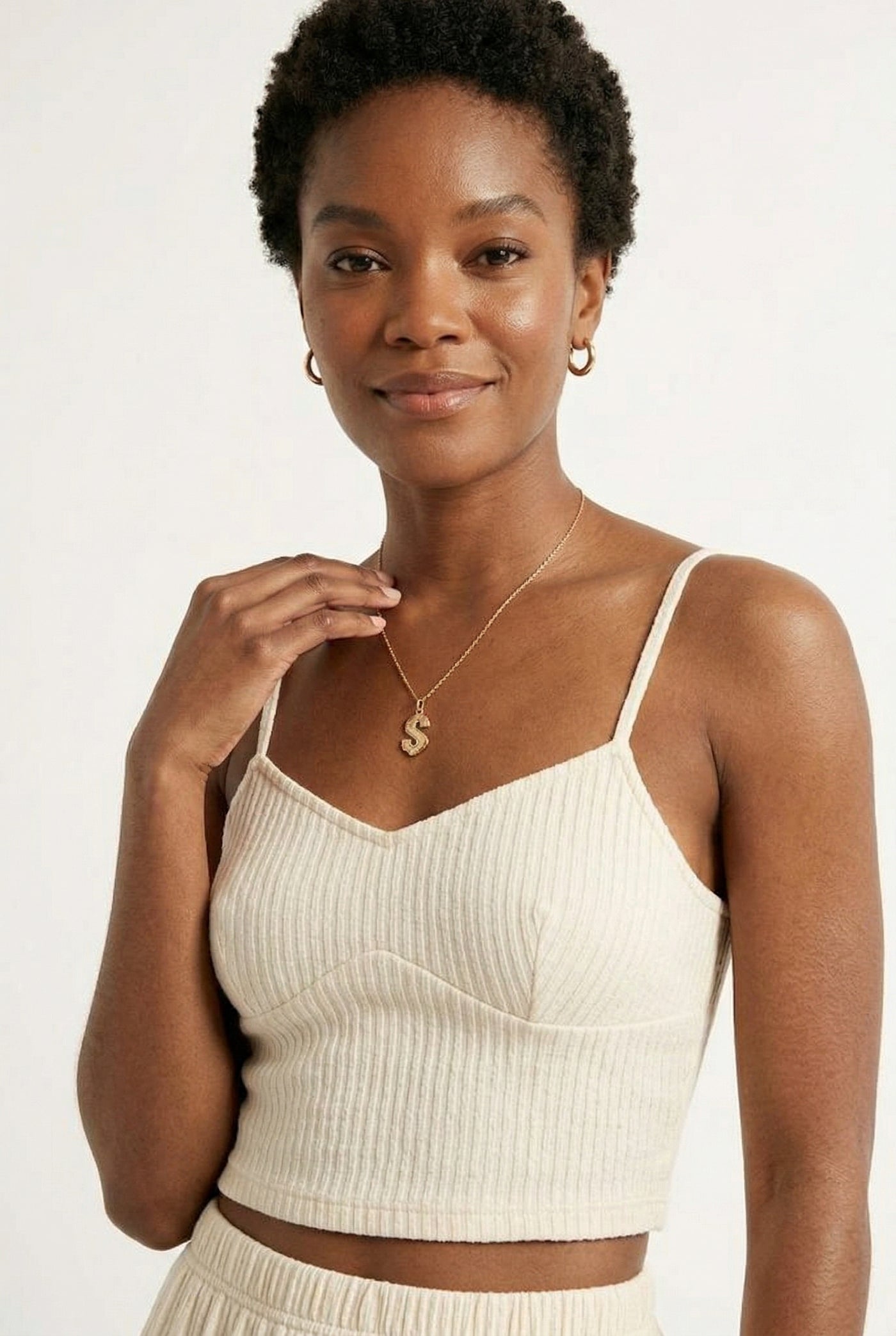 Woman modeling an Oat cream two-piece matching set featuring a spaghetti strap crop top and tiered maxi skirt