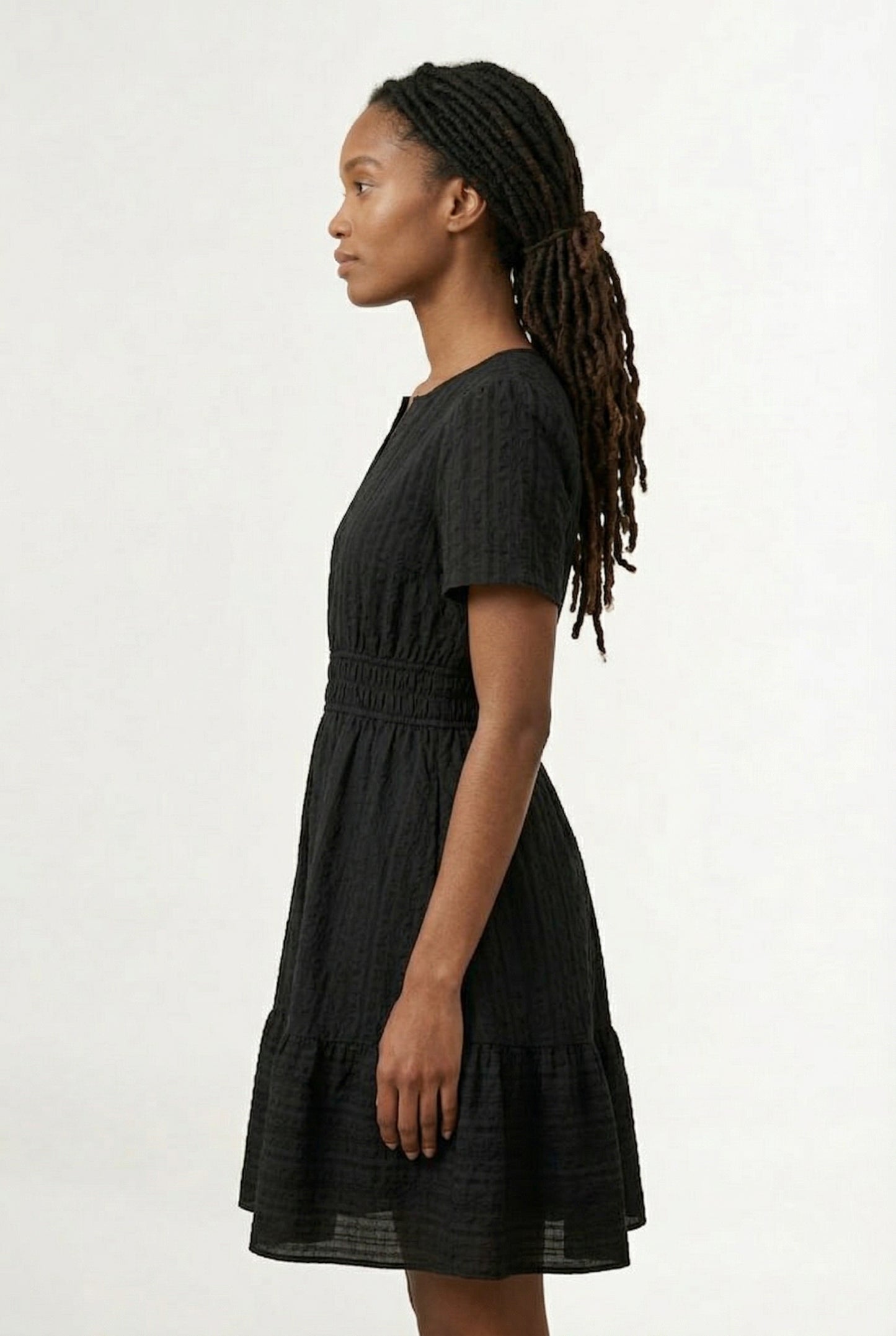 Woman wearing a short sleeve v-neck tiered dress in onyx black
