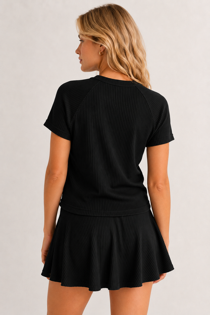 Woman wearing an onyx black short sleeve top and matching mini skirt lounge set.