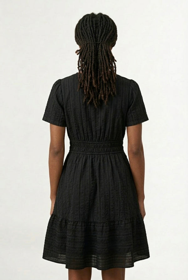 Woman wearing a short sleeve v-neck tiered dress in onyx black