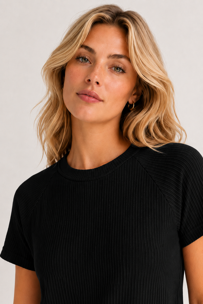 Woman wearing an onyx black short sleeve top and matching mini skirt lounge set.