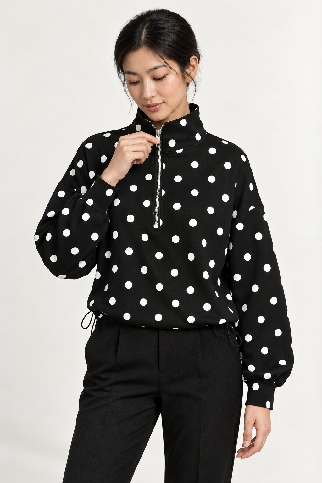 Pippa Polka-Dot Half-Zip in Black, raised zip detail with model holding the zipper pull.