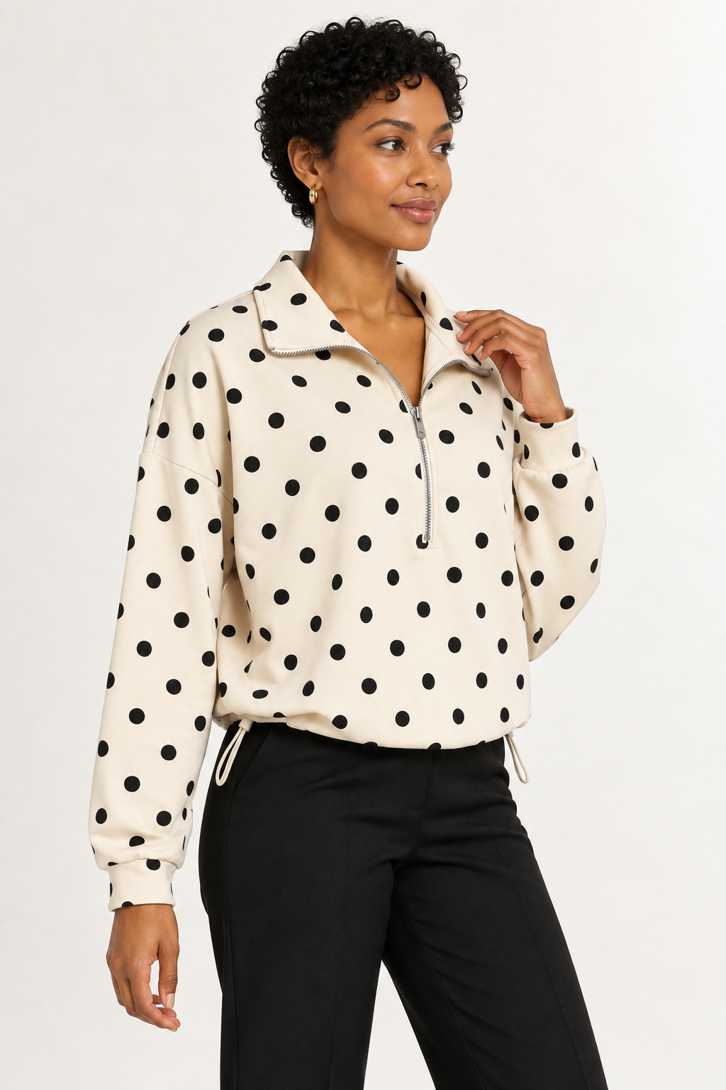 Pippa Polka-Dot Half-Zip in Cream, three-quarter view with hand at collar.