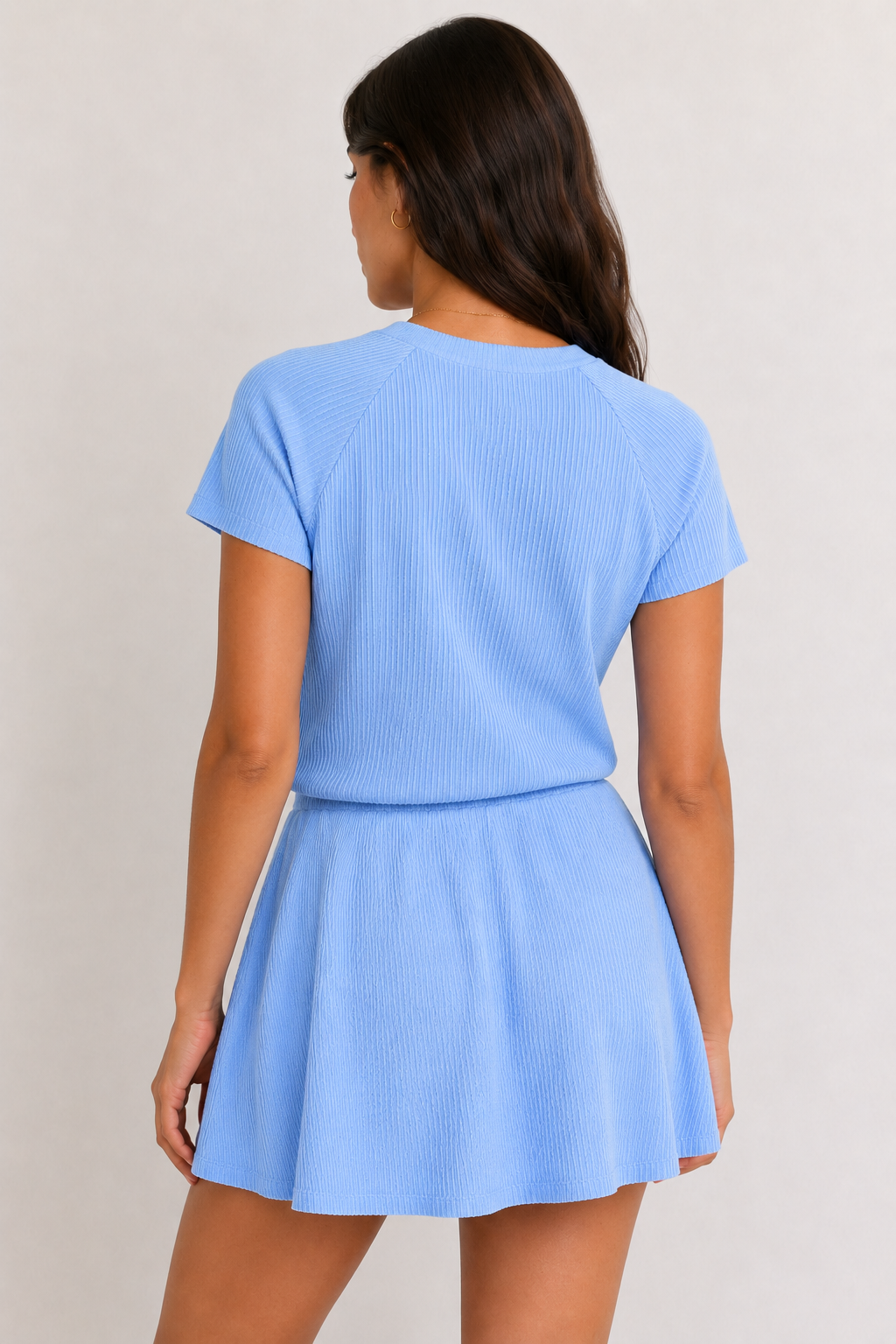 Woman wearing a powder blue short sleeve top and matching mini skirt lounge set.