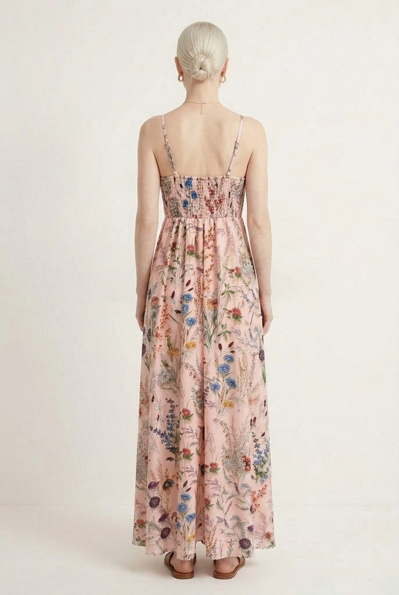 Woman wearing a rosewater pink floral print maxi dress with spaghetti straps