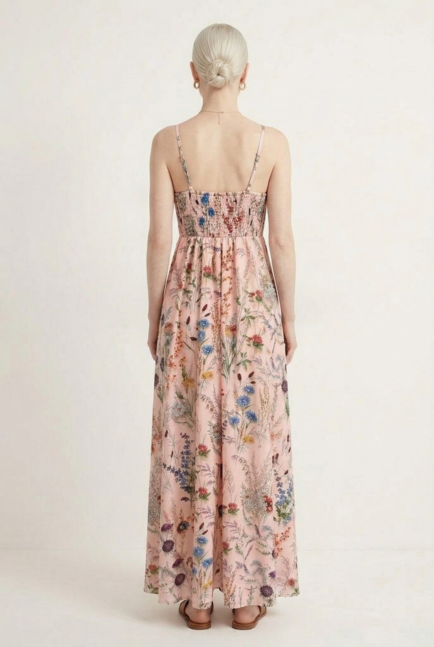 Woman wearing a rosewater pink floral print maxi dress with spaghetti straps
