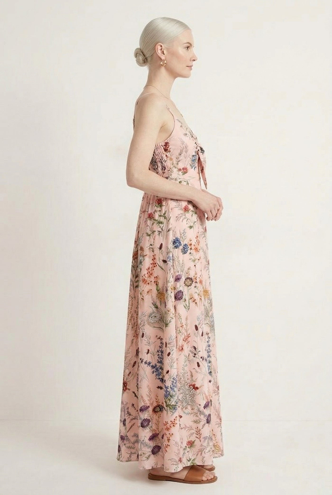 Woman wearing a rosewater pink floral print maxi dress with spaghetti straps