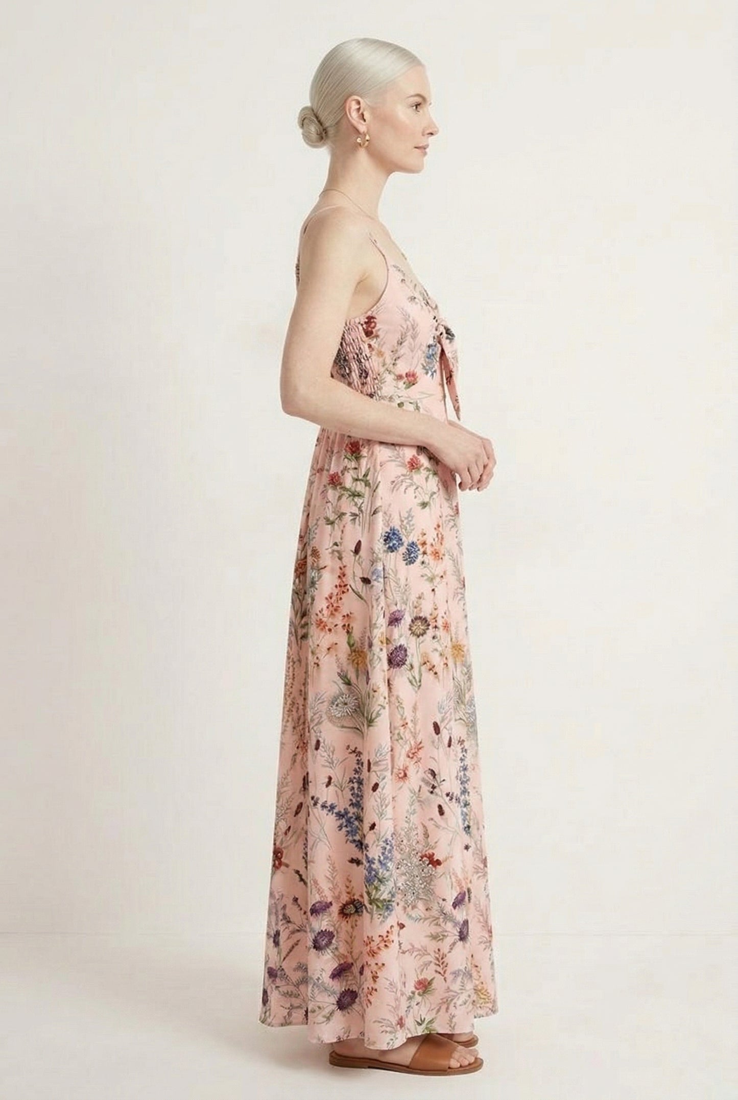 Woman wearing a rosewater pink floral print maxi dress with spaghetti straps