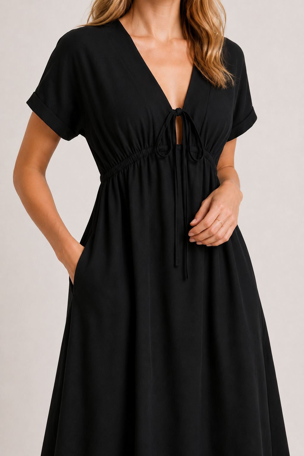 Model standing against a white studio background wearing the black onyx Sabine midi.