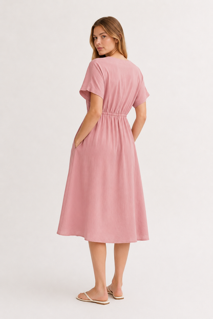 Studio shot of a model wearing the vintage rose pink Sabine midi, facing forward.