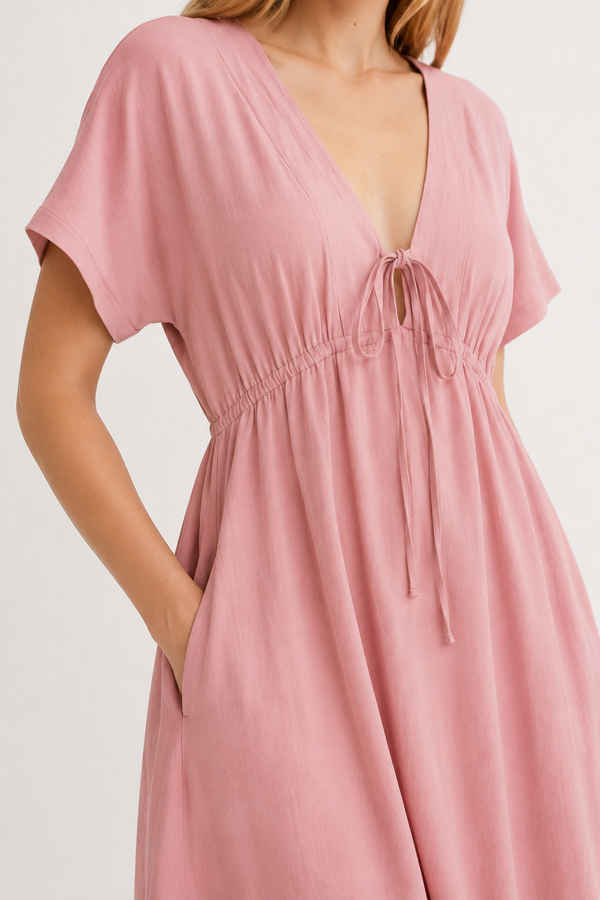 Studio shot of a model wearing the vintage rose pink Sabine midi, facing forward.