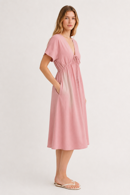 Studio shot of a model wearing the vintage rose pink Sabine midi, facing forward.