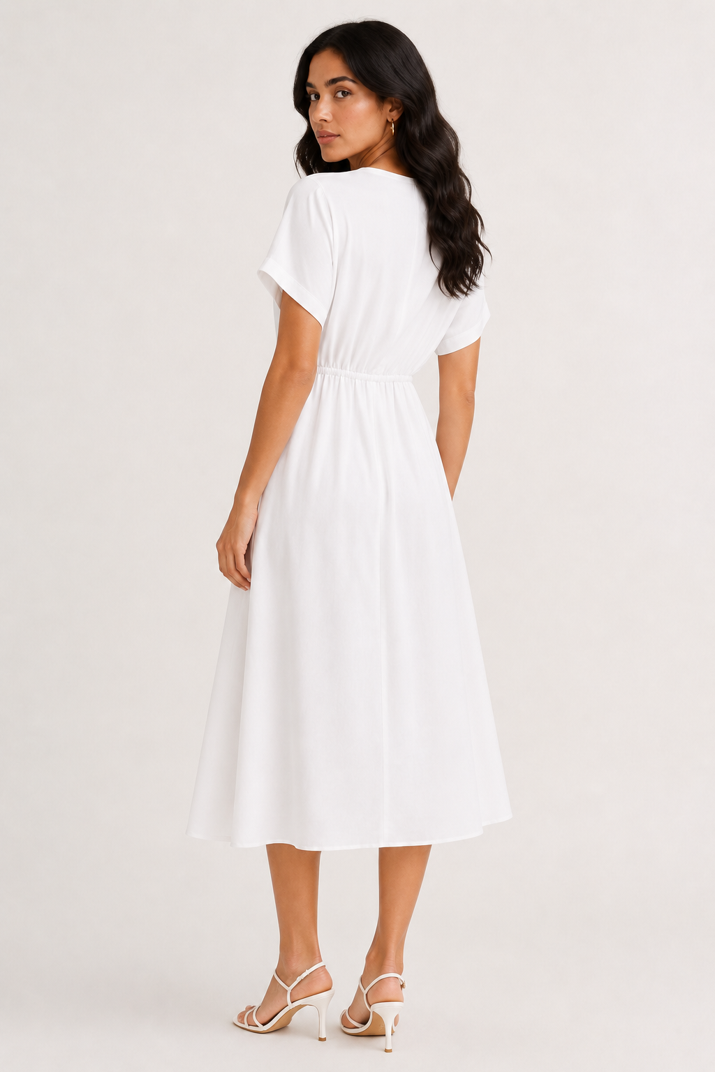 Professional studio portrait of a woman wearing the crisp white Sabine midi against a seamless background.