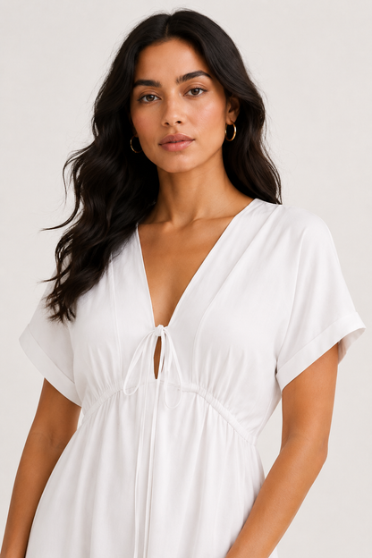 Professional studio portrait of a woman wearing the crisp white Sabine midi against a seamless background.