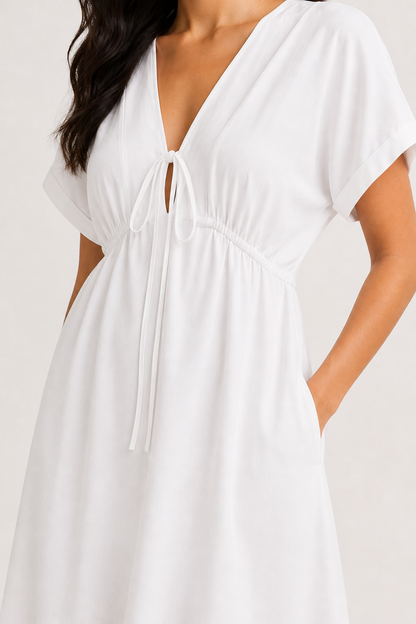 Professional studio portrait of a woman wearing the crisp white Sabine midi against a seamless background.