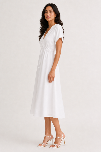 Professional studio portrait of a woman wearing the crisp white Sabine midi against a seamless background.