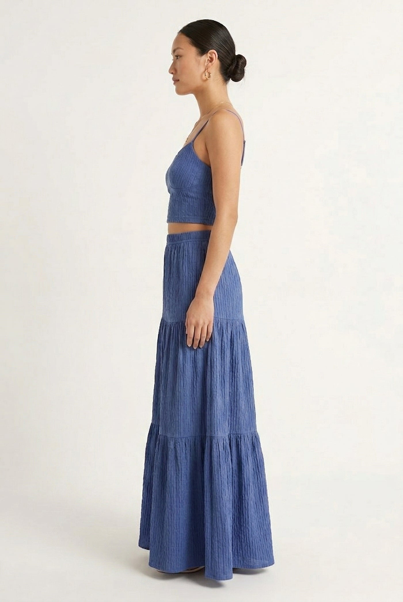 Woman modeling a Slate Blue two-piece matching set featuring a spaghetti strap crop top and tiered maxi skirt