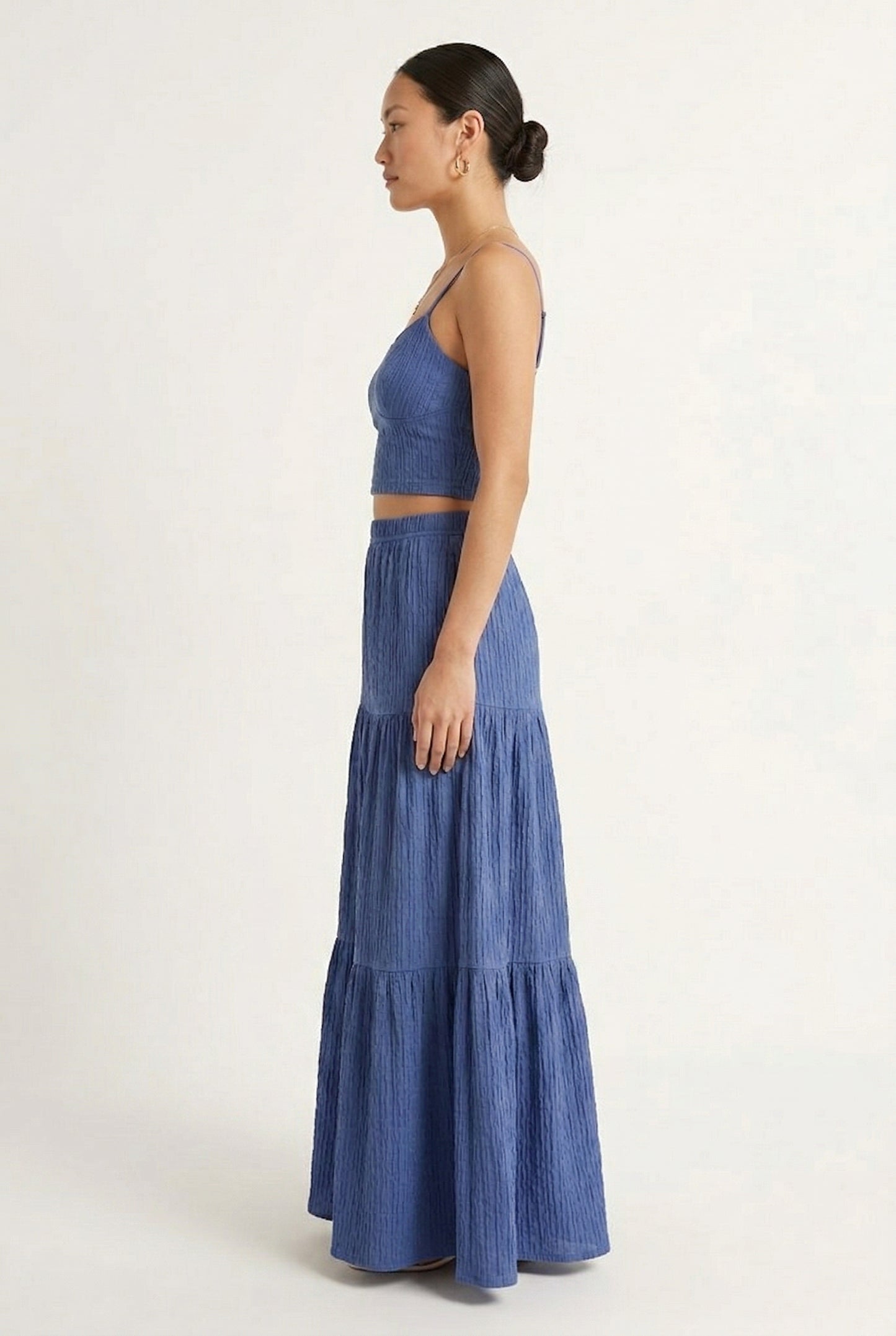 Woman modeling a Slate Blue two-piece matching set featuring a spaghetti strap crop top and tiered maxi skirt