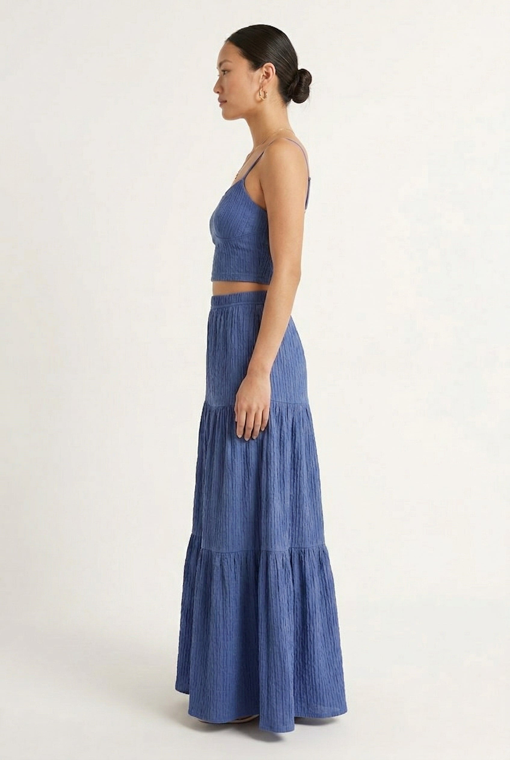 Woman modeling a Slate Blue two-piece matching set featuring a spaghetti strap crop top and tiered maxi skirt