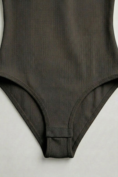 Model wearing a Smoked Onyx black square neck one-piece swimsuit