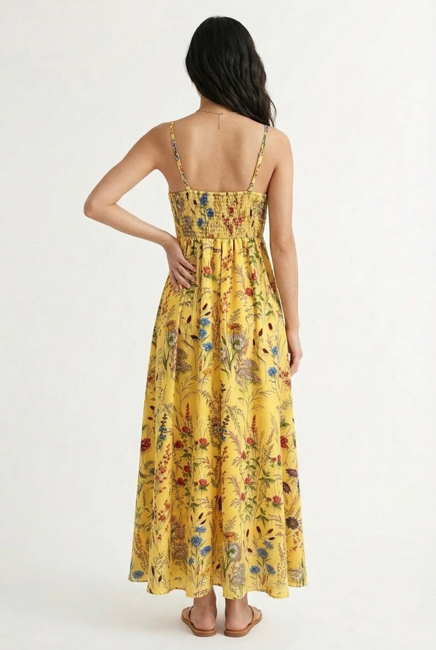 Woman wearing a soft honey yellow floral print maxi dress with spaghetti straps