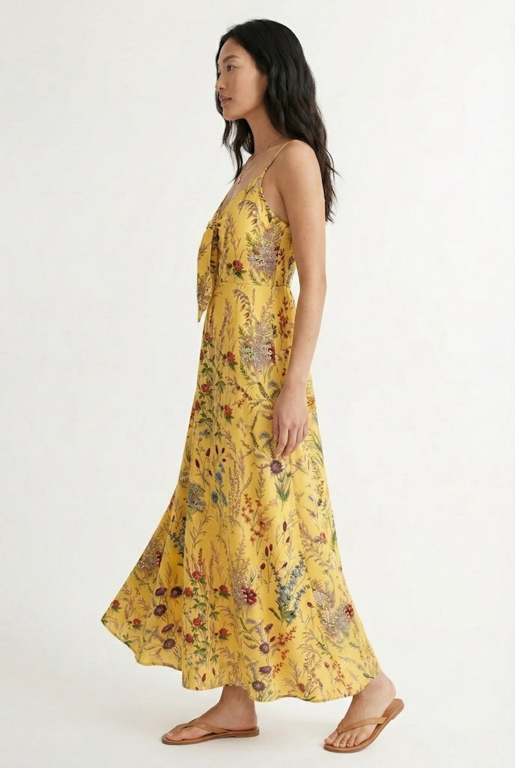 Woman wearing a soft honey yellow floral print maxi dress with spaghetti straps