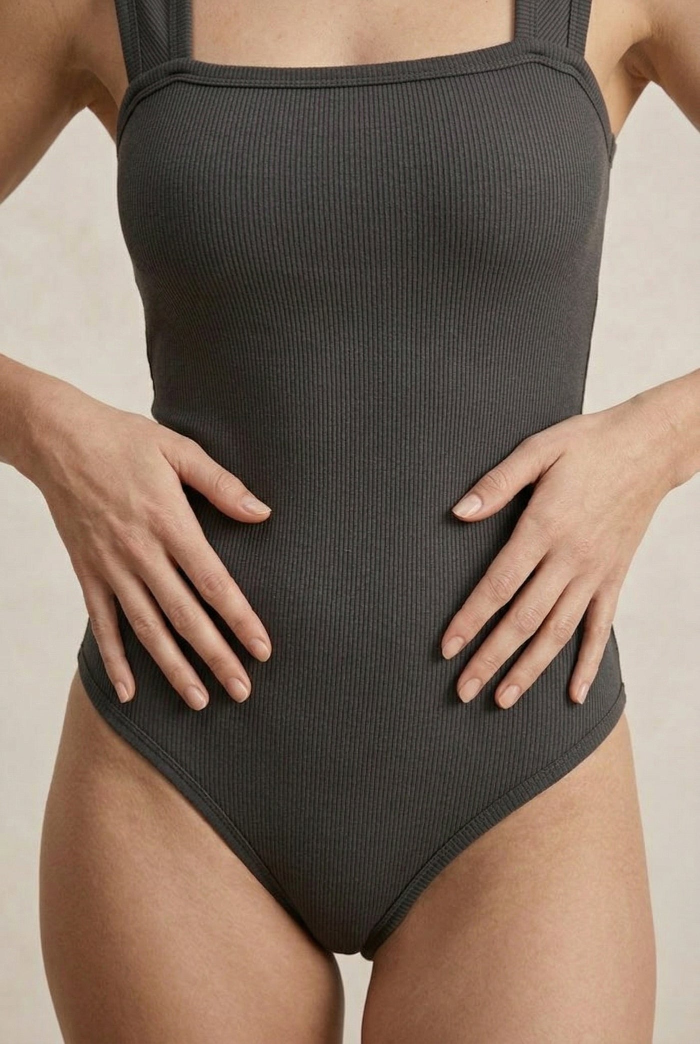 Model wearing a Smoked Onyx black square neck one-piece swimsuit