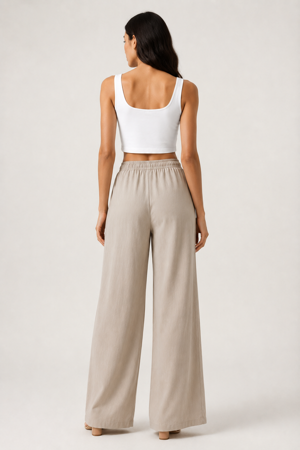 Woman modeling premium high-waisted wide-leg pants in light beige Light Birch against a clean studio background