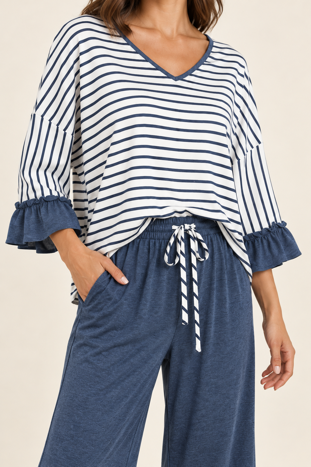 Close-up of the Tess set in Blue, showing the striped V-neck, ruffled cuffs and striped waist tie.
