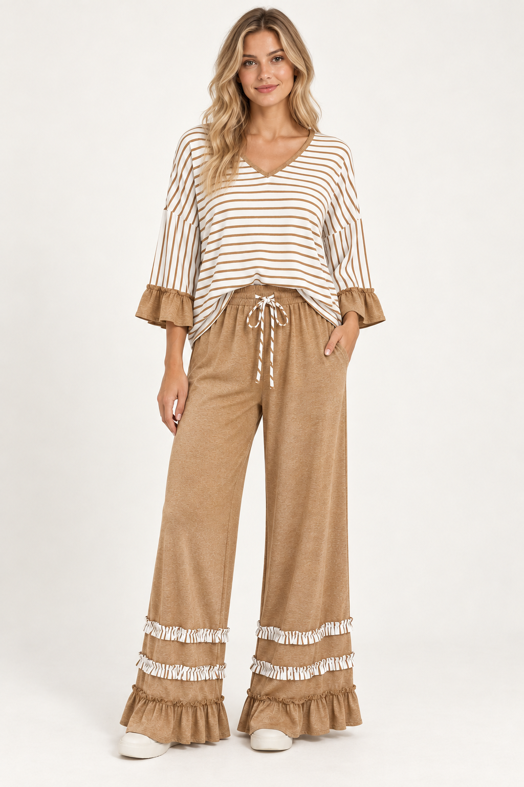 Woman wearing the Tess striped V-neck top and ruffle-hem pants in Camel, front view. #A6795A