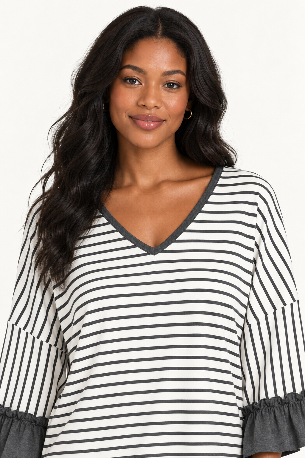 Close-up portrait of a woman wearing the Tess striped top in Charcoal, showing the V-neckline and ruffled sleeves.