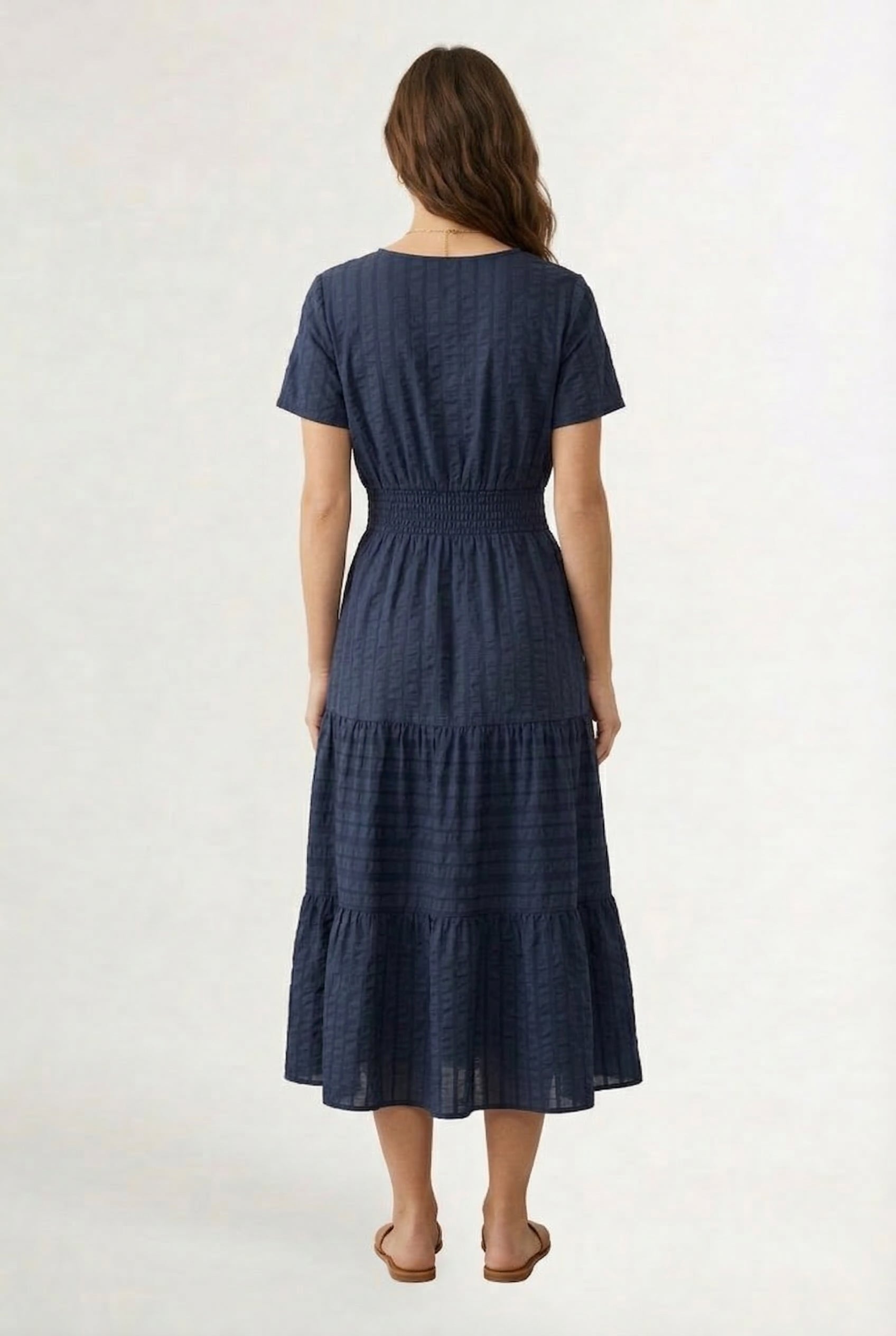 A woman wearing a dark navy Total Eclipse short-sleeve midi dress with a button-down front.