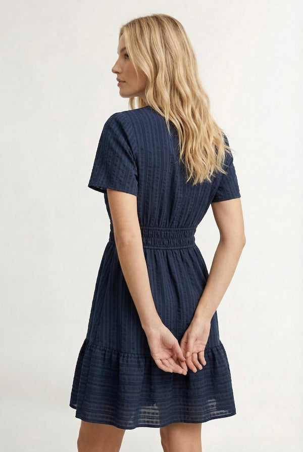 Woman wearing a short sleeve v-neck tiered dress in total eclipse navy blue