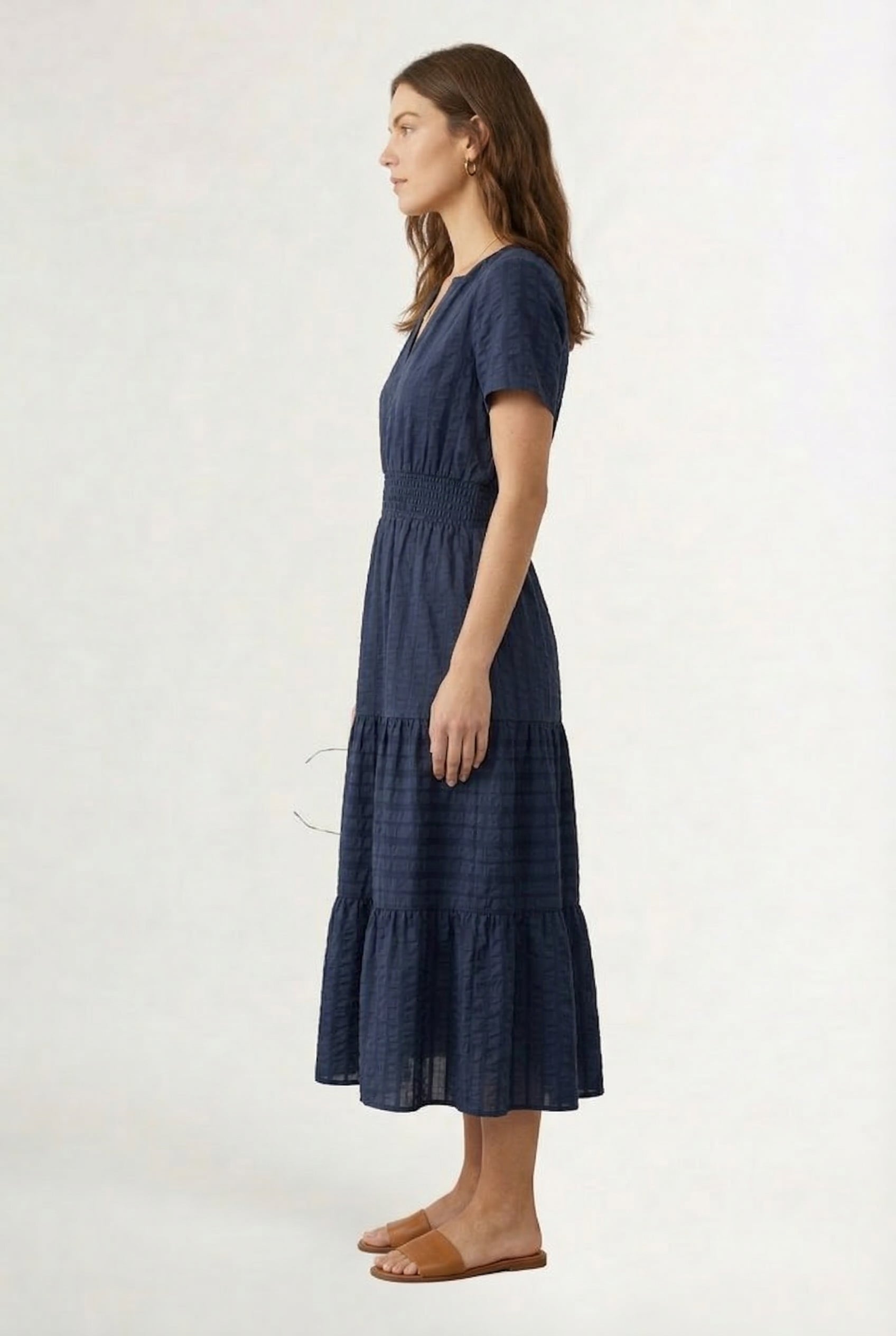 A woman wearing a dark navy Total Eclipse short-sleeve midi dress with a button-down front.