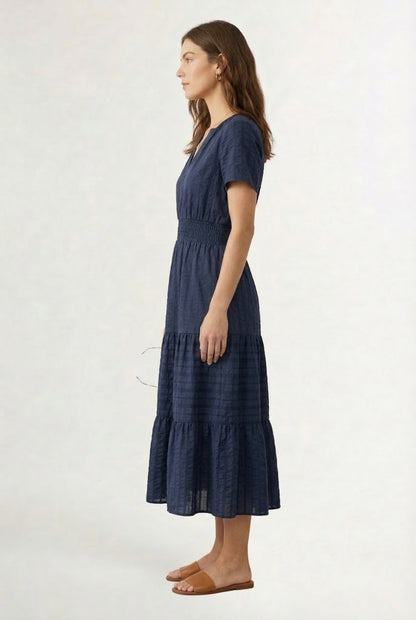 A woman wearing a dark navy Total Eclipse short-sleeve midi dress with a button-down front.