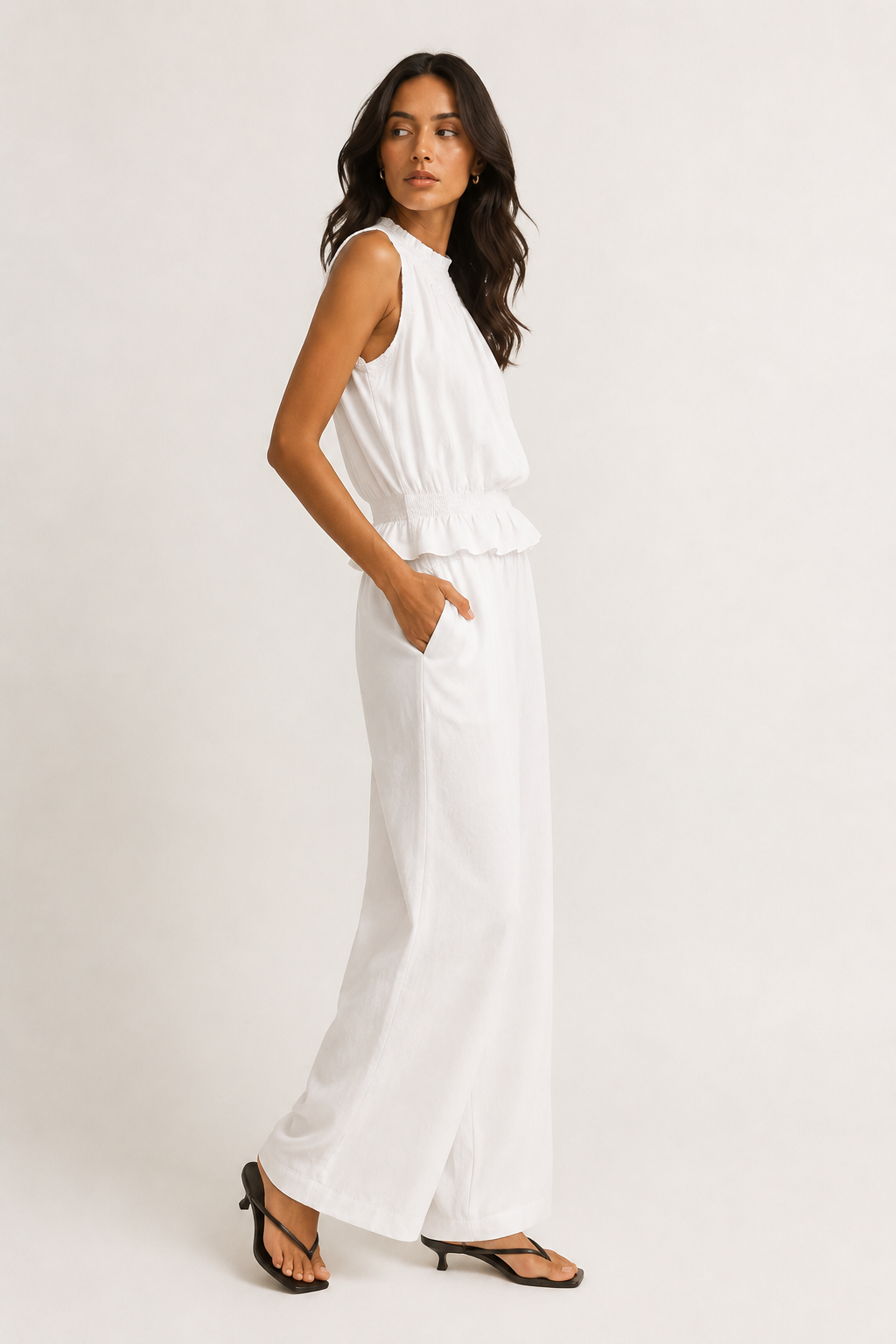 Woman wearing a premium minimalist blanc white two piece set with sleeveless top and wide leg pants