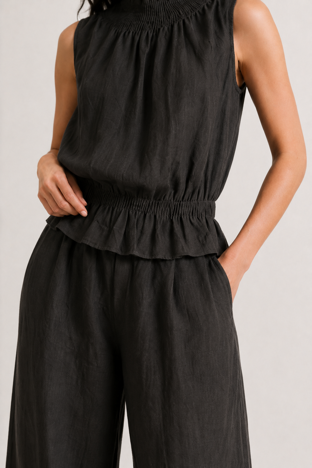Woman wearing a premium minimalist washed onyx black two piece set with sleeveless top and wide leg pants