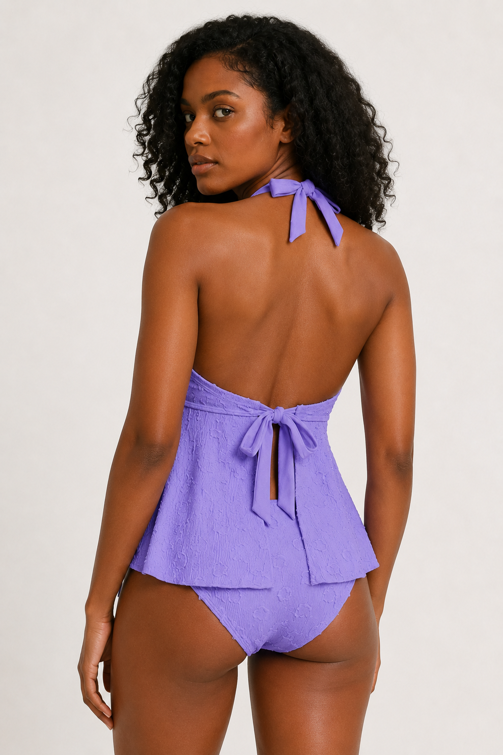 Woman modeling a Wisteria purple tiered ruffle halter tankini swimsuit