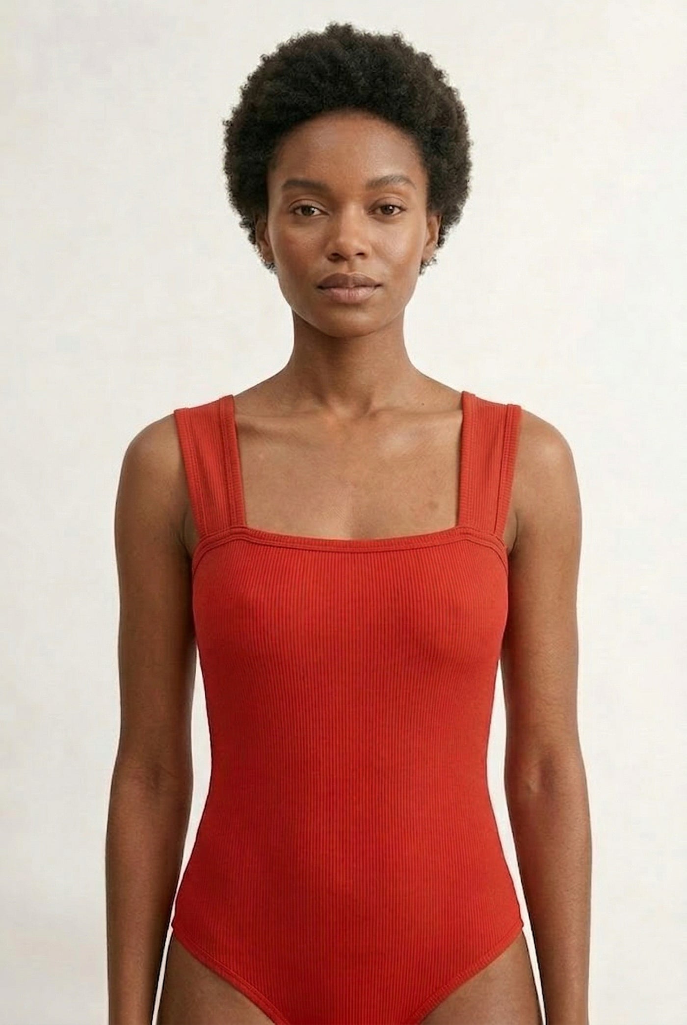 Model wearing a Cayenne red square neck one-piece swimsuit