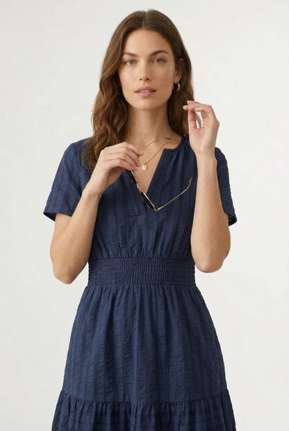 A woman wearing a dark navy Total Eclipse short-sleeve midi dress with a button-down front.